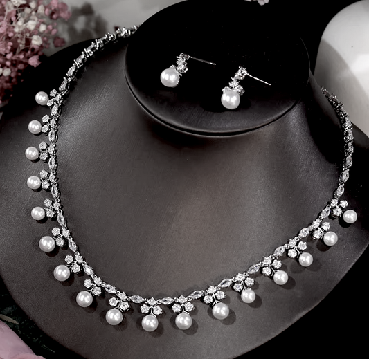 A bridal pearl necklace set with a collar design and drop pearl earrings, displayed on a mannequin bust